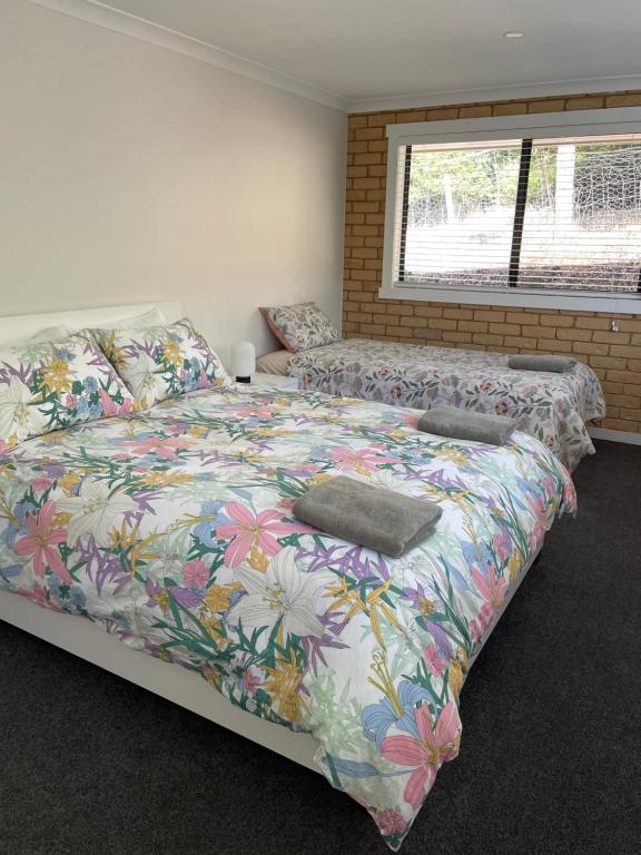 1 Schlafzimmer mit 2 Betten mit Blumenbettdecke in der Unterkunft Sandstone Family Apartment in Grindelwald