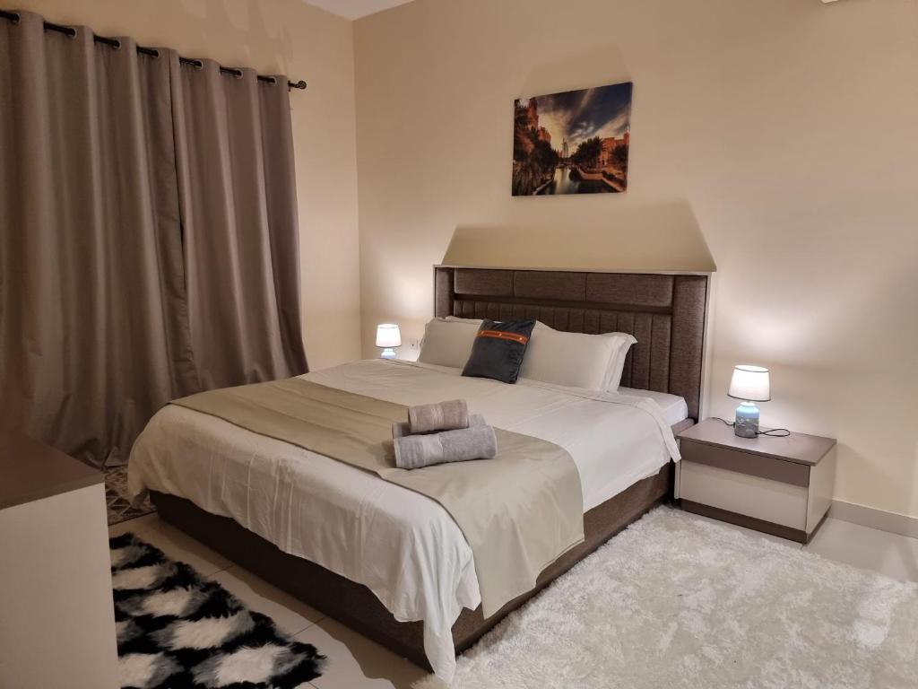 a bedroom with a large bed with two night stands at Deluxe Rooms in Al Mamzar SHJ Shared bathroom in Sharjah