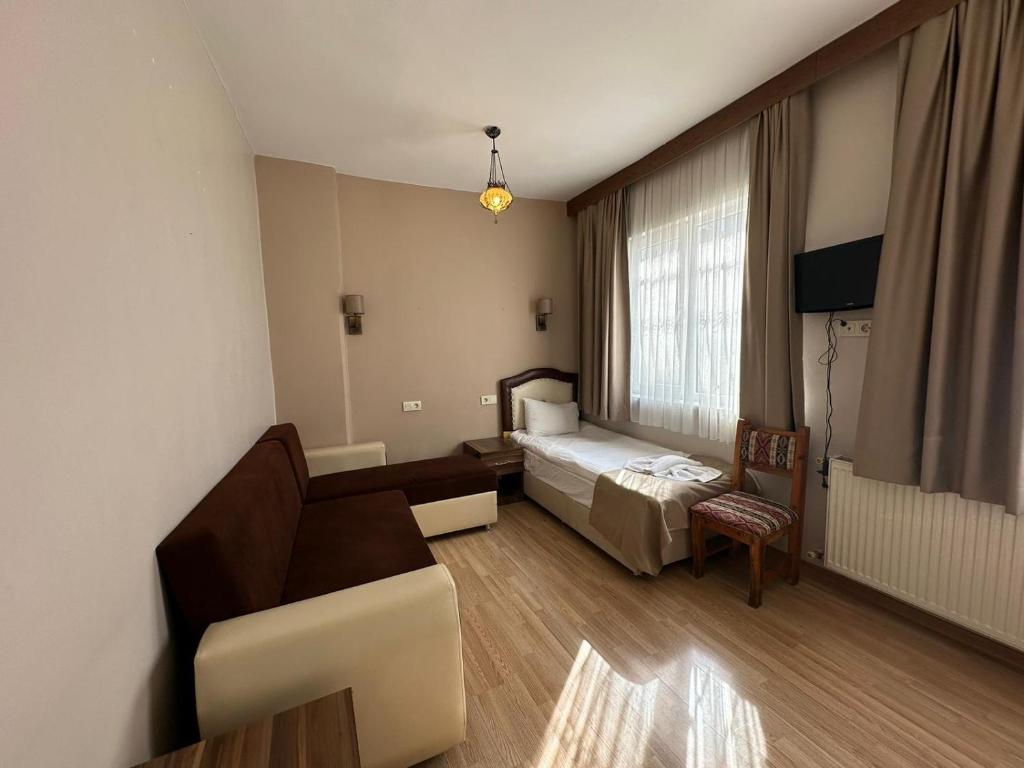 um quarto de hotel com uma cama e um sofá em Buhara Family Stone House em Istambul