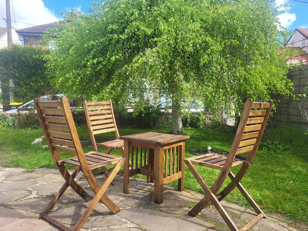 2 chaises, une table, une table et un arbre dans l'établissement J1 St-Quentin-en -Yvelines Studio en Rez de jardin avec parking, à Trappes