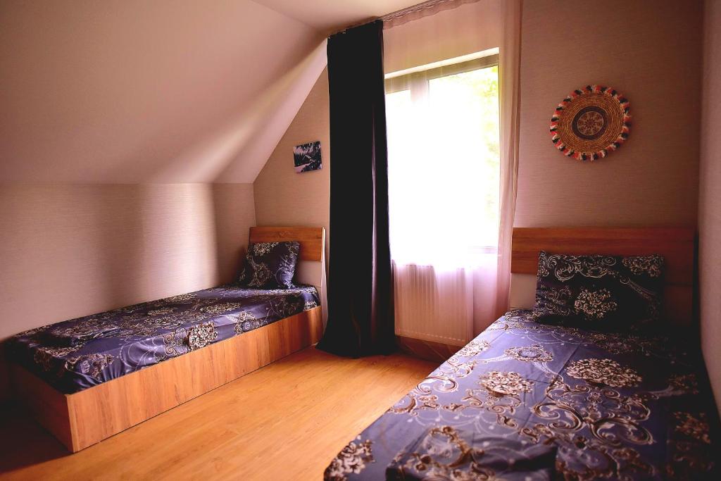 a small bedroom with two beds and a window at Chalet Resort Weekend Borjomi in Borjomi