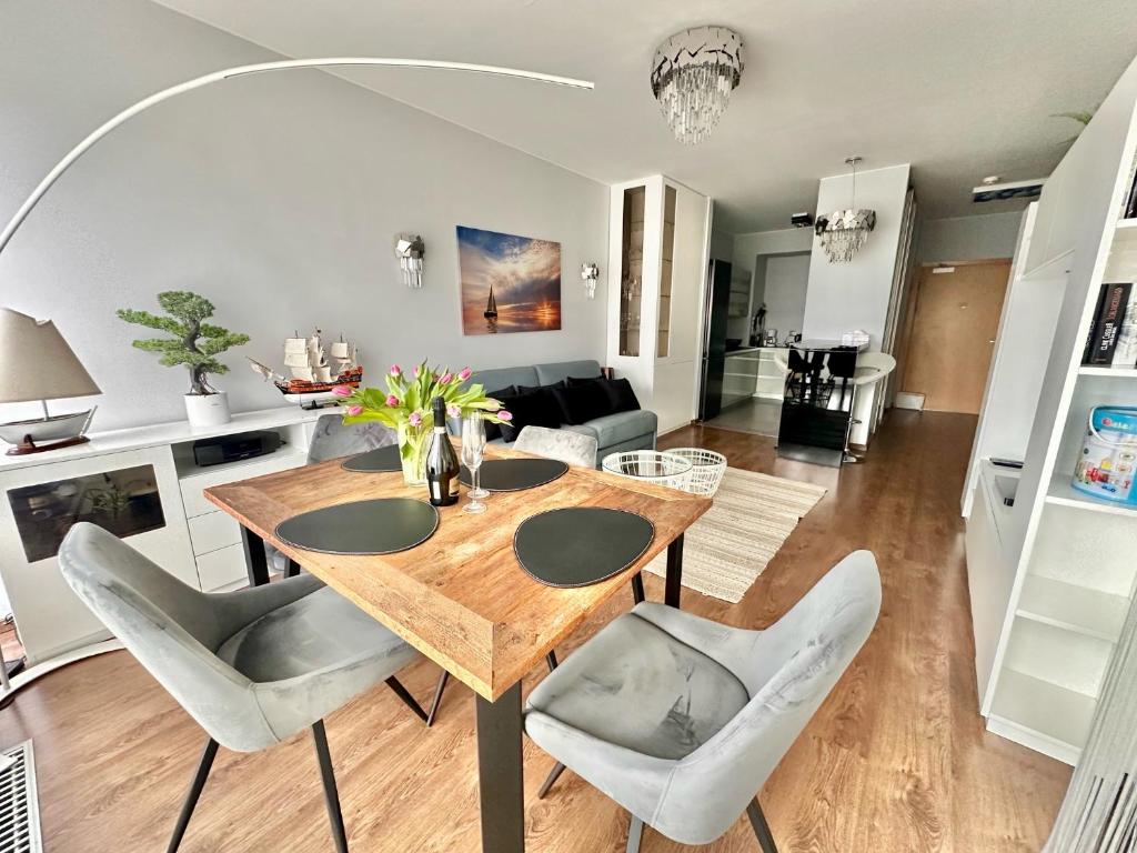 a dining room and living room with a table and chairs at Your Holidays Playa Baltis in Międzyzdroje