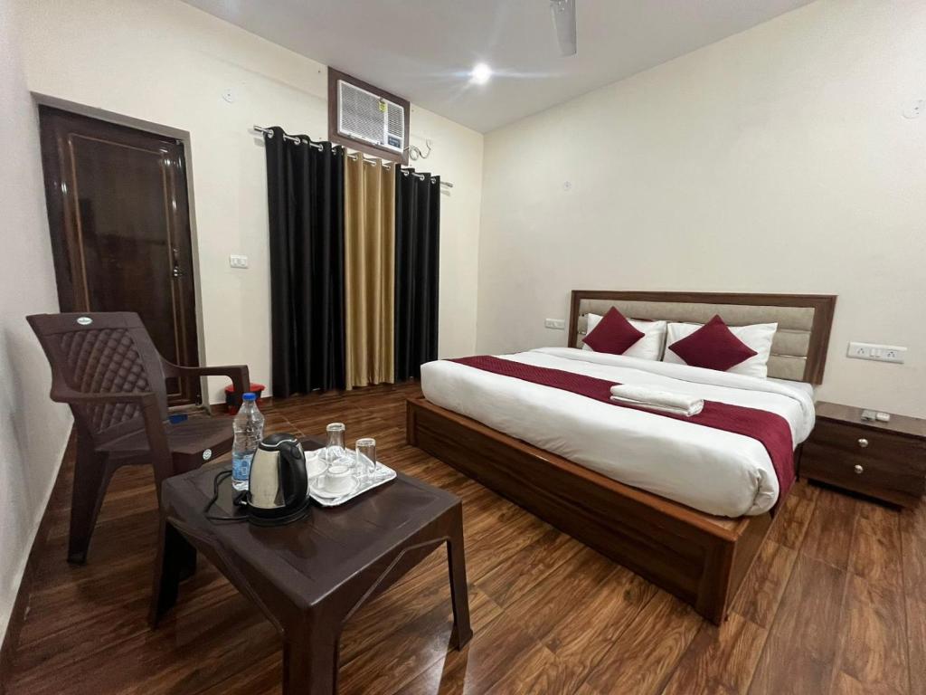 a hotel room with a bed and a table and a chair at Hotel Badal Inn - Safdarjung Enclave in New Delhi