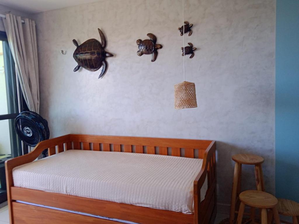a bedroom with a bed and some turtles on the wall at VG Sun Cumbuco 406 in Cumbuco