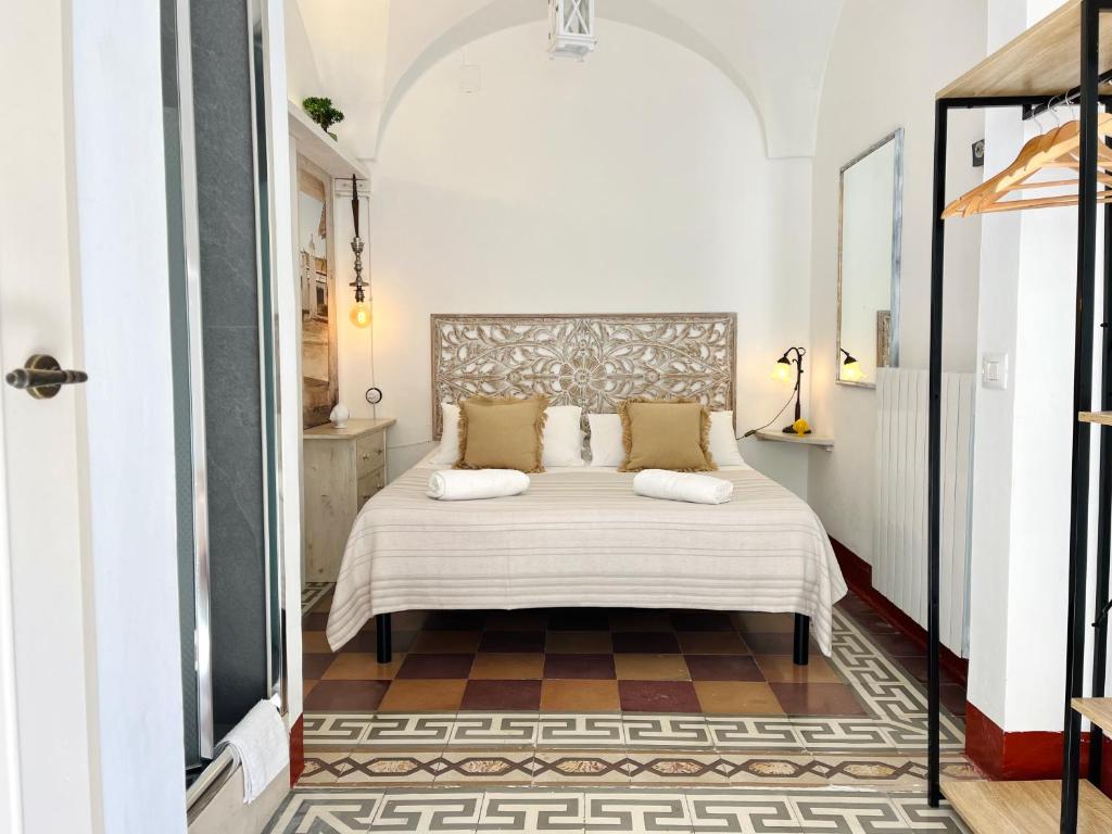 a bedroom with a white bed with two pillows at Dimora Antica Perla in Fasano