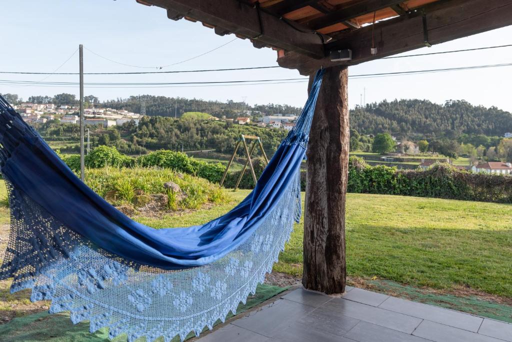 a blue hammock with a view of a field at Casa da Aldeia in Vilela