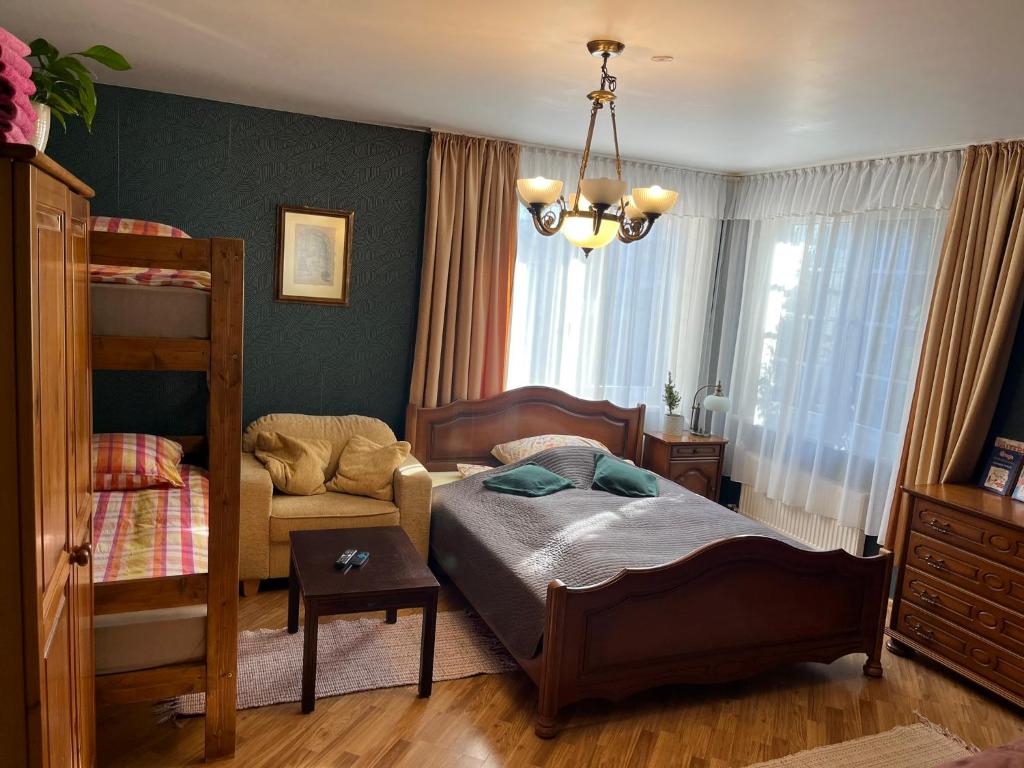 een slaapkamer met een stapelbed en een stoel bij Family house room in Salacgrīva