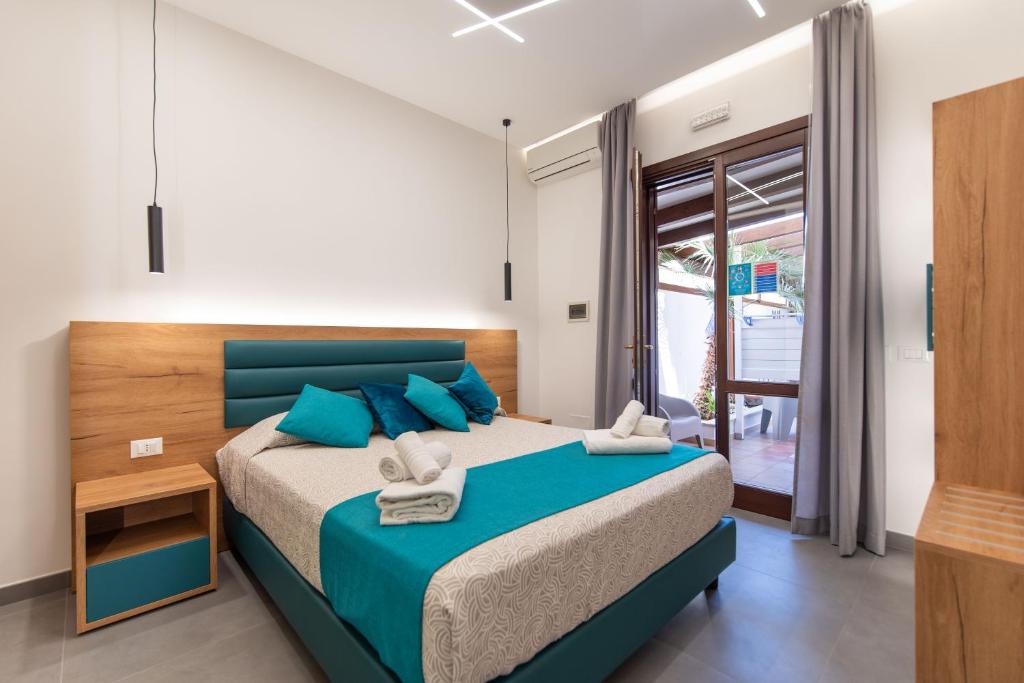 a bedroom with a large bed with blue pillows at Room & Breakfast Aloe in San Vito lo Capo
