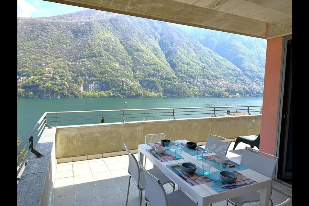 a table and chairs on a balcony with a view of a lake at Riflessi sul lago apt – Laglio in Laglio