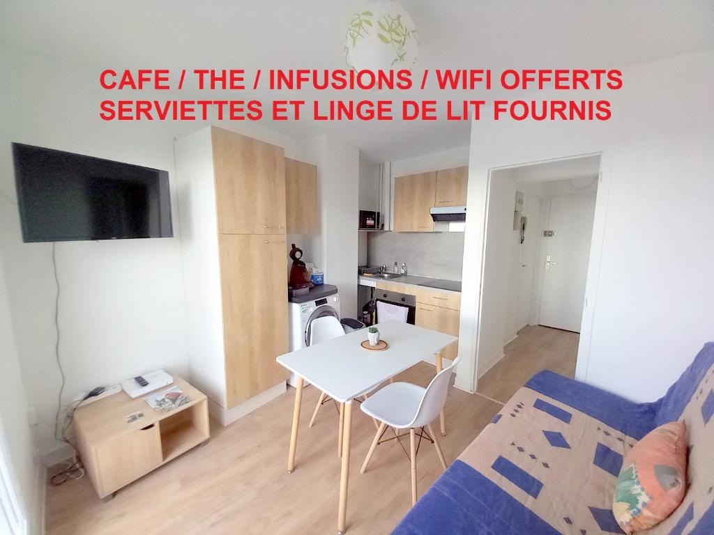 uma pequena sala de estar com uma mesa branca e cadeiras em Appartement 28m2 proche gare SNCF+café+thé+WIFI gratuits em Orléans