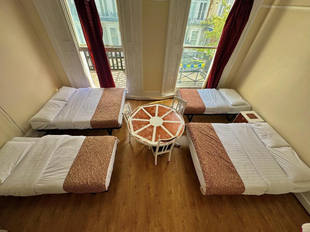 a room with four beds and a window at Anwar House in London