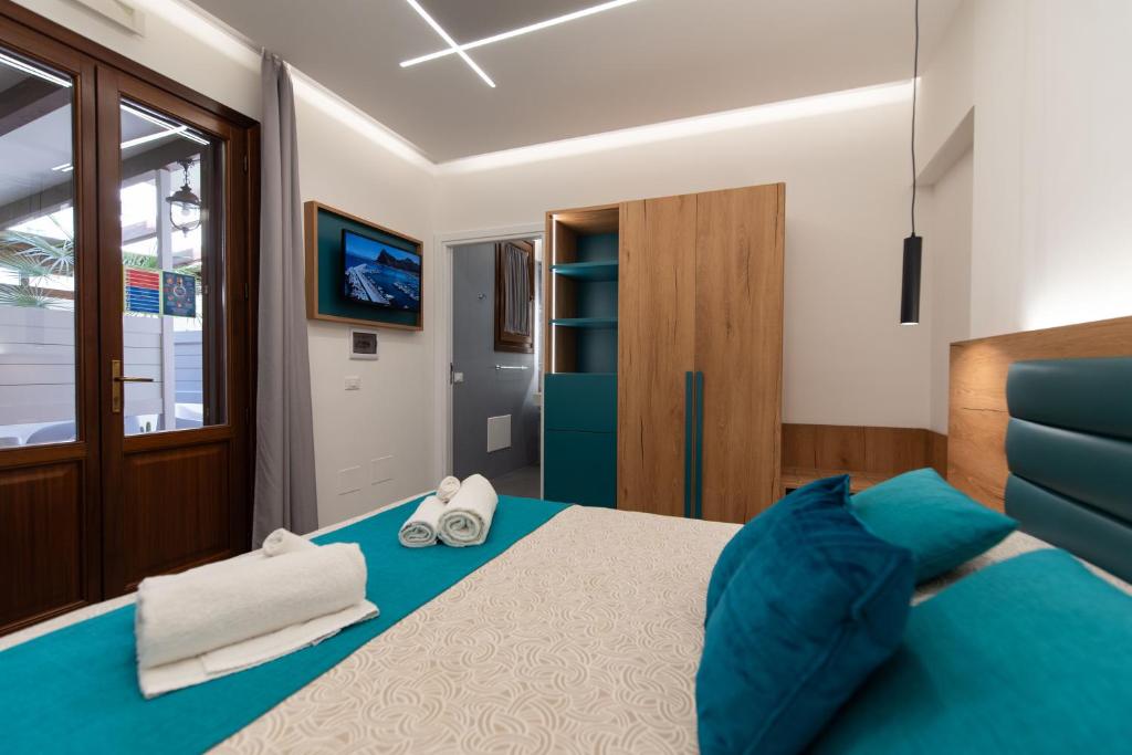 a bedroom with a bed and a tv on the wall at Room & Breakfast Aloe in San Vito lo Capo
