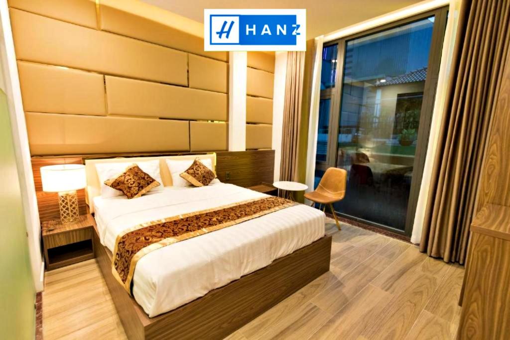 a hotel room with a bed and a large window at HANZ MyMy Hotel in Ho Chi Minh City