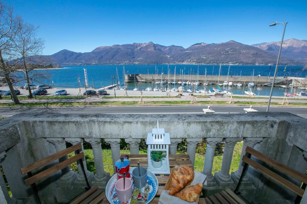 a balcony with two benches and a view of the water at Residenza Gardenia Lake View Luino Center - Happy Rentals in Luino