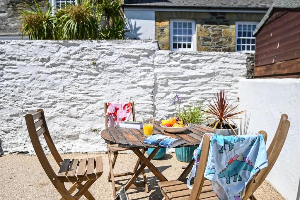 un tavolo con un cesto di frutta e due sedie di Palms 2 - Central, 5 mins walk to beach + parking! a Newquay