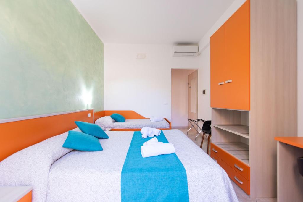 a bedroom with a bed with blue and orange pillows at Room & Breakfast Aloe in San Vito lo Capo