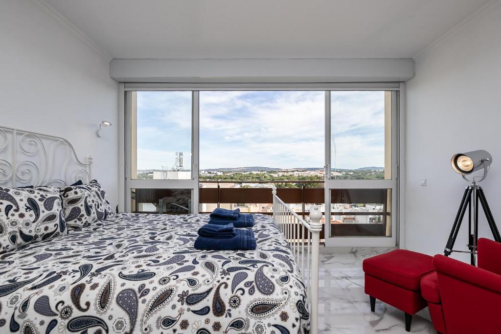 a bedroom with a bed and a large window at T0 Vilamoura Downtown in Vilamoura