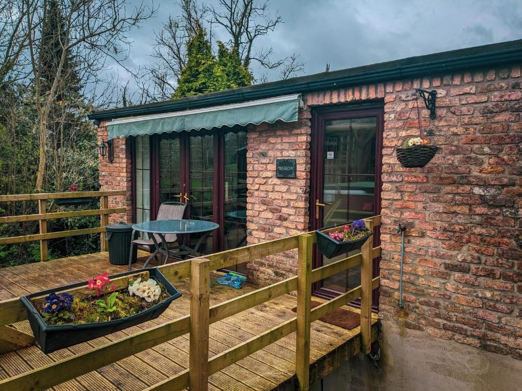 a small brick house with a wooden deck at Aughnahoy Staycations Portglenone in Portglenone