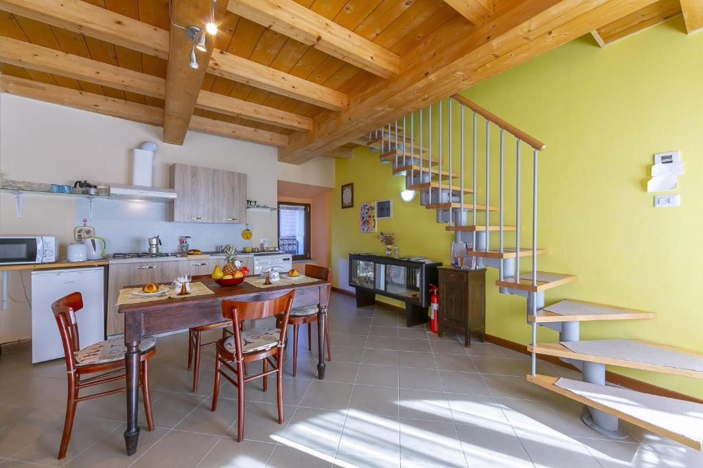 kuchnia ze stołem i krzesłami oraz schodami w obiekcie Casa Baroni few min from Orta Lake - Happy Rentals w mieście Madonna del Sasso