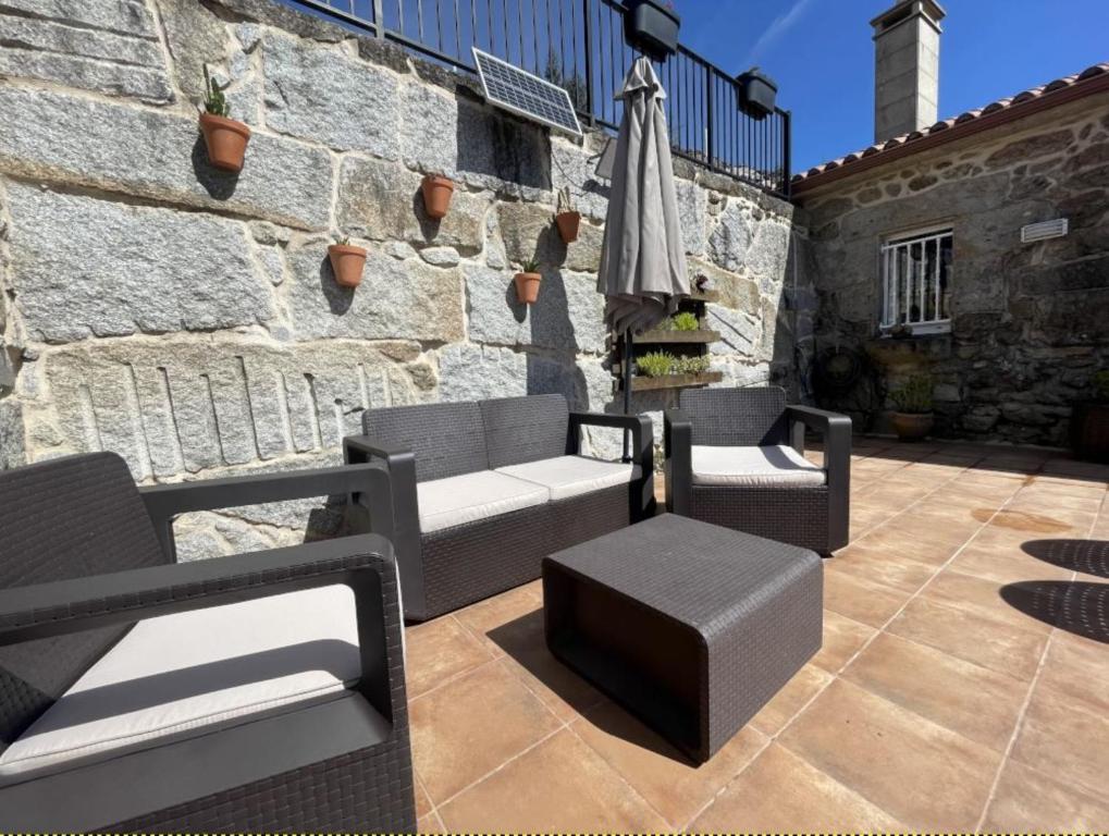 a patio with two chairs and an umbrella at YourHouse A Casa Da Corona casa rural in Ourense