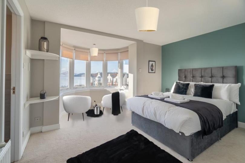 a large bedroom with a large bed and a chair at Penthouse at the Bay near Edinburgh in Saint Davids