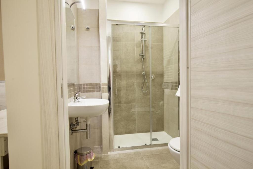 W łazience znajduje się prysznic, umywalka i toaleta. w obiekcie Six Rooms w mieście Neapol