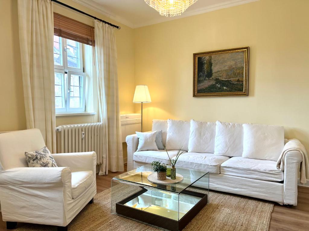 a living room with a white couch and a coffee table at Wohlfühl-Apartment in historischer Burg nahe Fulda in Schlitz