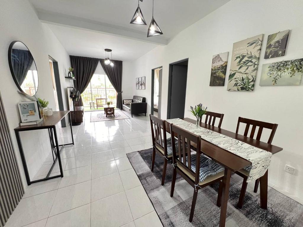 comedor y sala de estar con mesa y sillas en Aufa Homestaymuslim's 2 at Emerald Avenue, en Brinchang