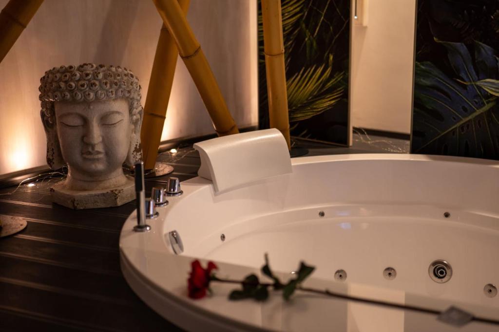 una bañera con una estatua de una cabeza junto a ella en Suite Home3 beb, en Bisceglie