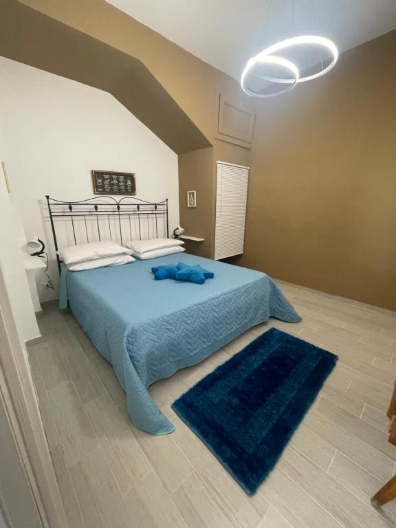 ein Schlafzimmer mit einem Bett mit blauer Bettwäsche und einem blauen Teppich in der Unterkunft ..A DUE PASSI DAL MARE in Terrasini