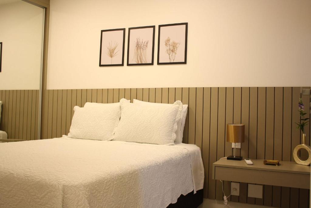 a bedroom with a bed with four pictures on the wall at Noroeste Easy by CentoEdez in Brasília