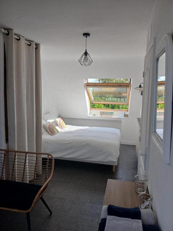 ein kleines Schlafzimmer mit einem Bett und einem Fenster in der Unterkunft Plan B in Quimper