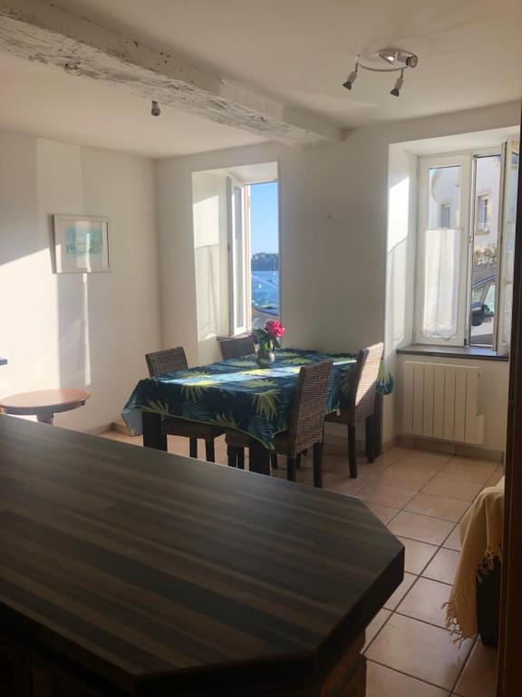 une salle à manger avec une table, des chaises et des fenêtres dans l'établissement Solidor, à Saint-Malo