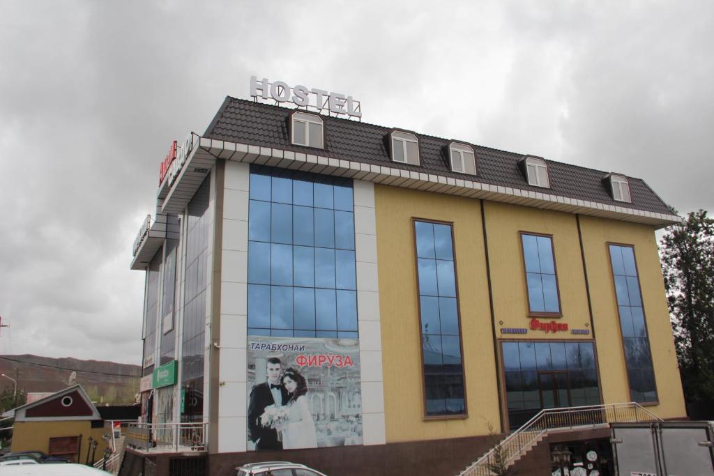 a building with a sign on the top of it at Hostel Asham in Panjakent