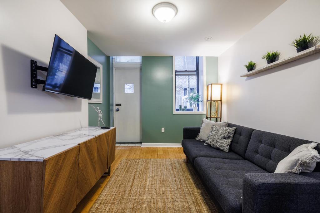 a living room with a couch and a flat screen tv at Ultimate Urban living at Centrally Located Lofts in New York