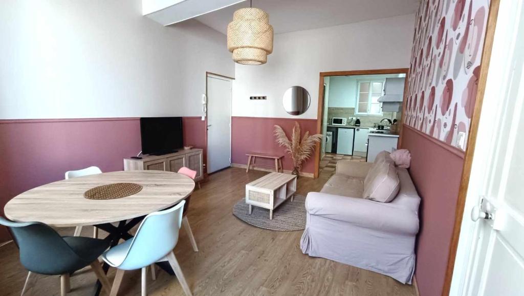 een woonkamer met een tafel en stoelen en een keuken bij Terre de Bourgogne - Appartement au centre ville d'Avallon in Avallon