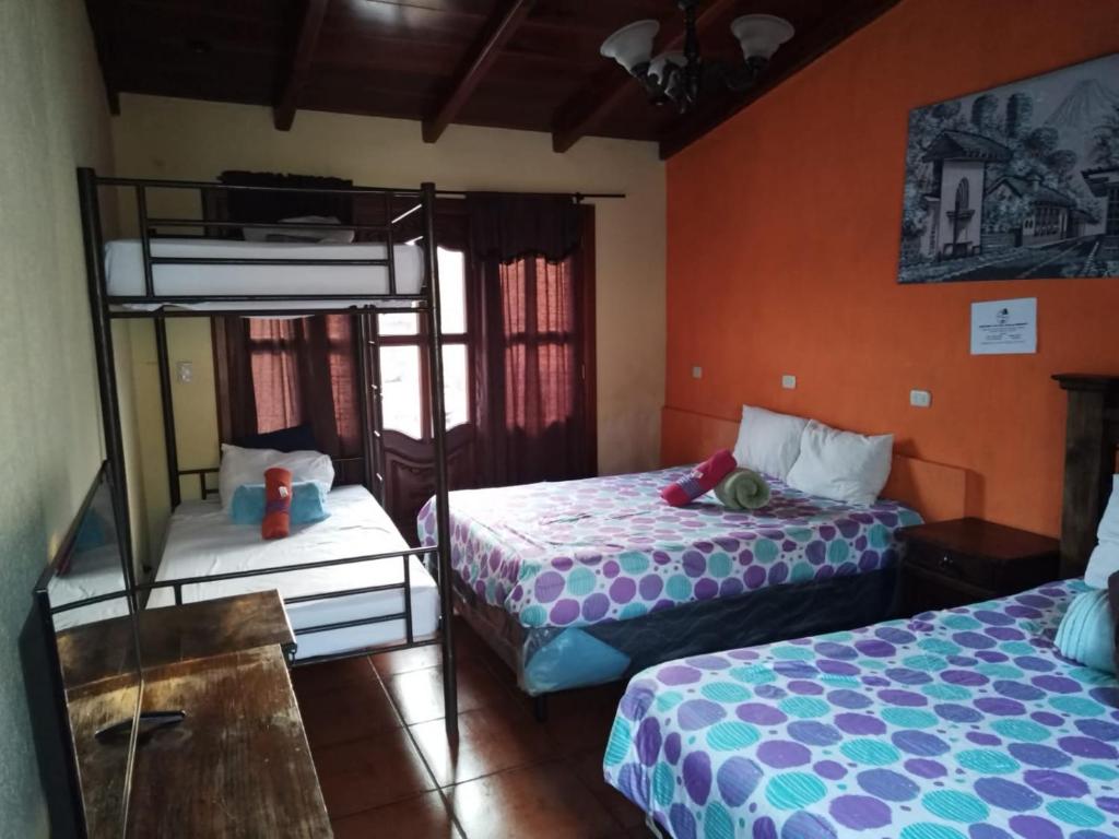 a bedroom with two beds and a bunk bed at Hotel city of antigua s.a in Antigua Guatemala