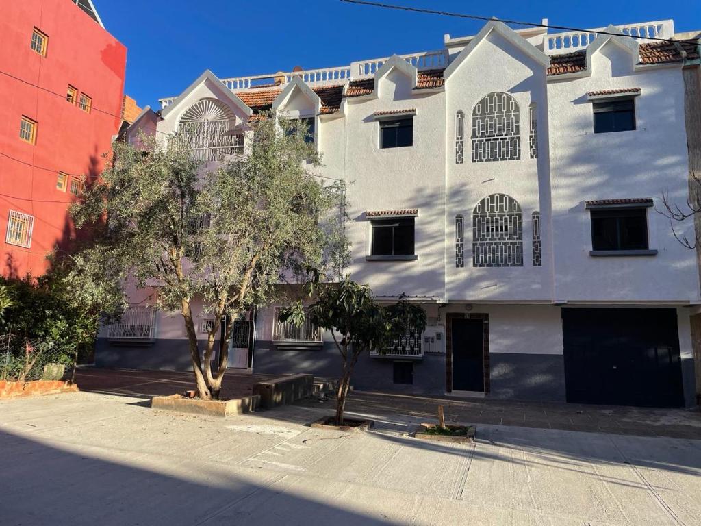 a white building with a tree in front of it at Chez azrou in Azrou