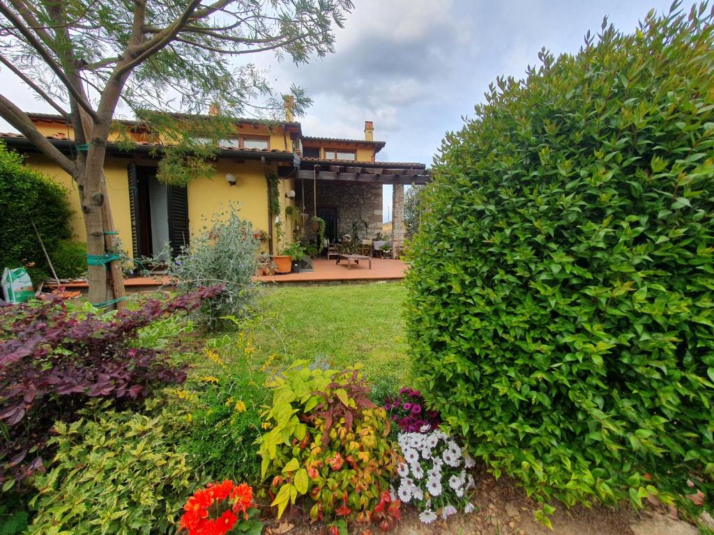 a garden with flowers in front of a house at Pietra E Glicine B&B in Pieve a Nievole