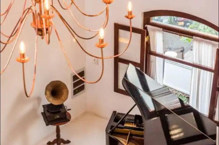 a room with a piano and a chandelier at Queen of Galle in Galle