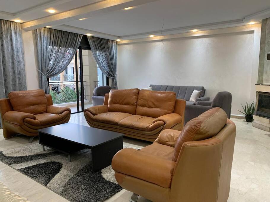 ラバトにあるBeautiful 3BR apartment in Hay Riad Rabatのリビングルーム(ソファ、椅子、テーブル付)