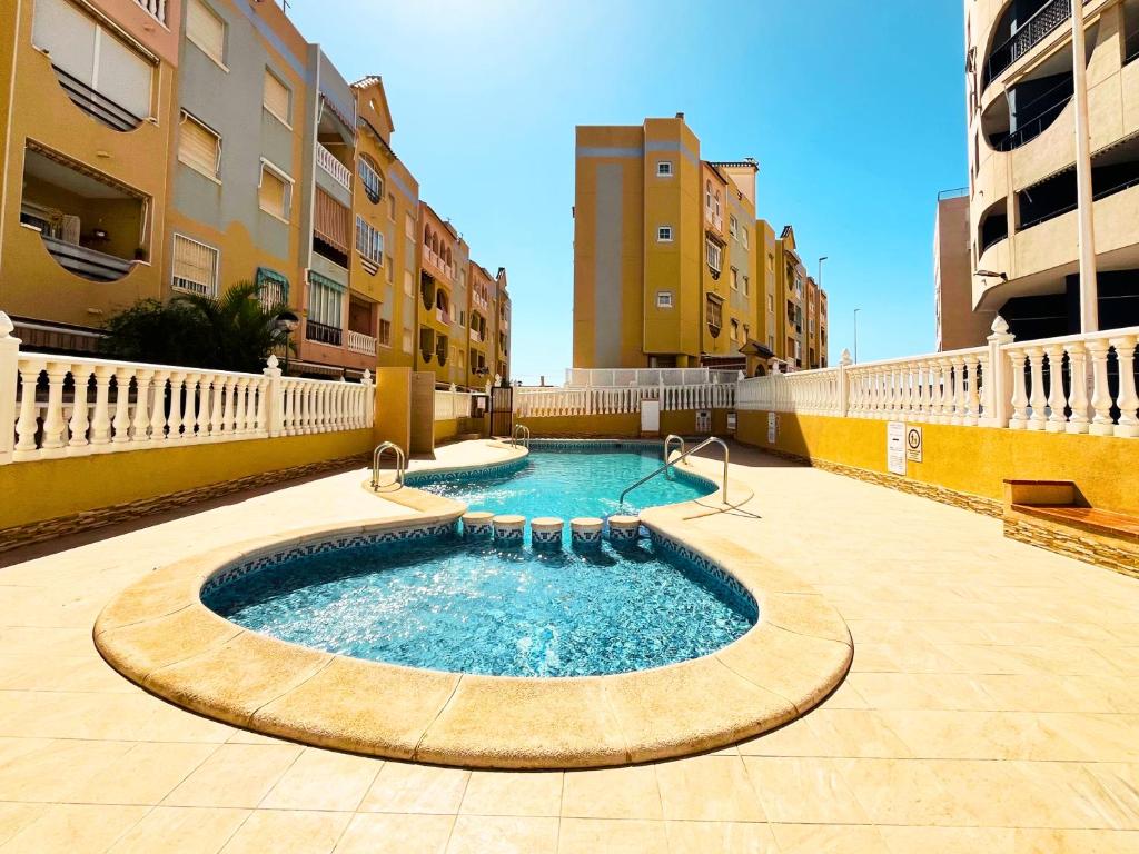 una piscina en medio de un edificio en Yellow Apartment-La Mata -2 min to beach, private garage, en La Mata