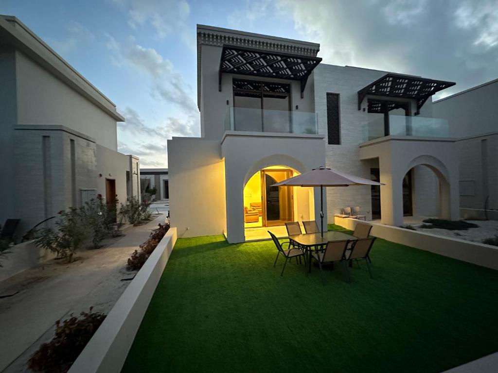 a house with a table and chairs on a lawn at Wonderful Ground Studio - Hawana Salalah Resort in Salalah