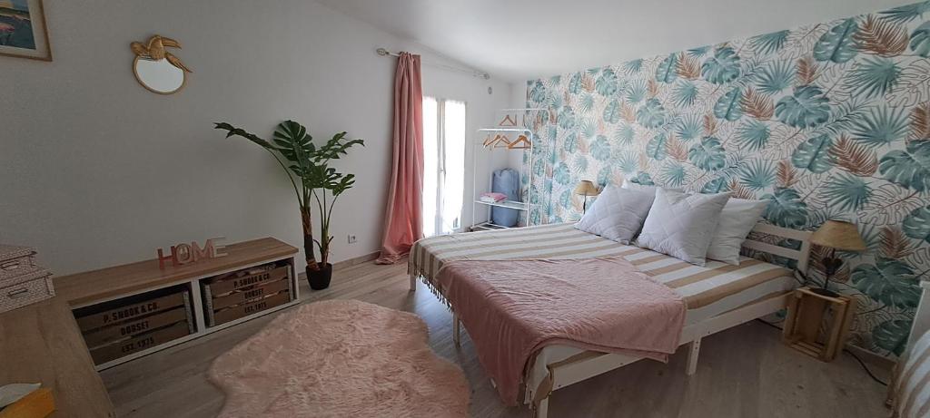 1 dormitorio con 1 cama con pared de flores en Maison centre Historique - LSM30Conciergerie-, en Saint-Gilles