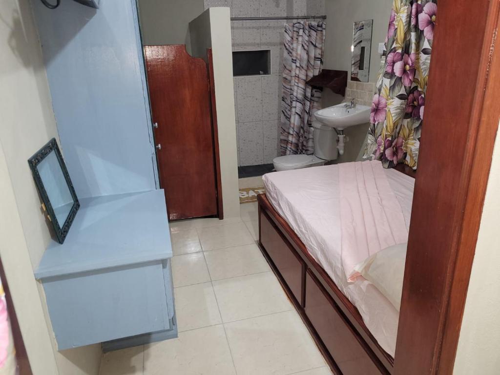 1 dormitorio con 1 cama y baño con lavamanos en Krystalise Loft, en Bridgetown