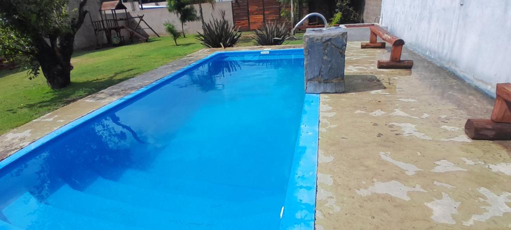 una piscina azul con un tobogán de agua en un patio en Mi Quincho Cañuelas en Cañuelas