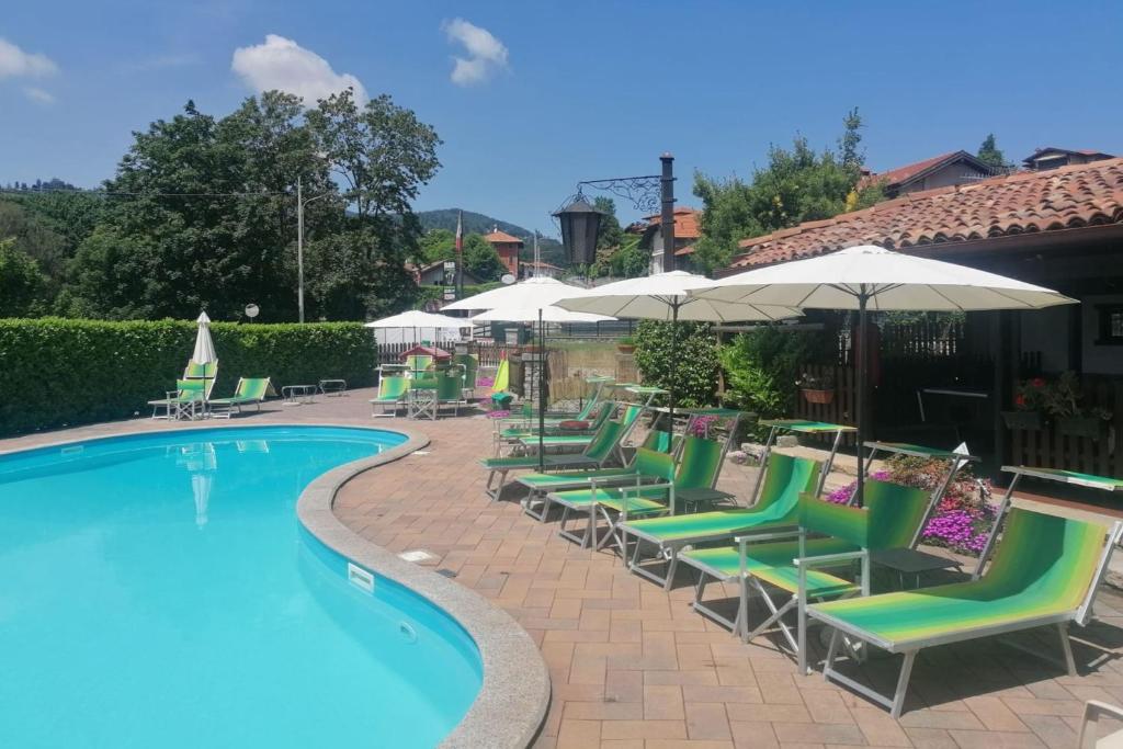a group of chairs and umbrellas next to a swimming pool at Residenza La Lanterna Pool and Relax - Happy Rentals in Gignese