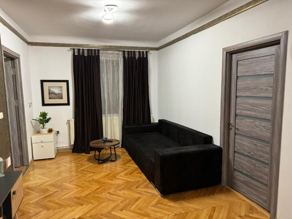 salon z czarną kanapą i stołem w obiekcie Mureșenilor Central Residence w Braszowie