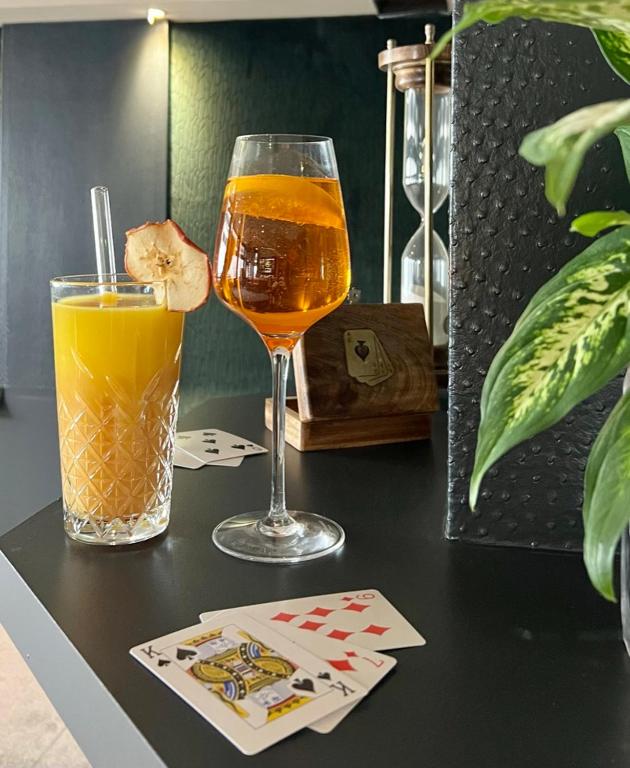 a glass of orange juice and a drink on a table at Le Trophée Boutique Hôtel Spa- La Loggia Appart'hôtel in Deauville
