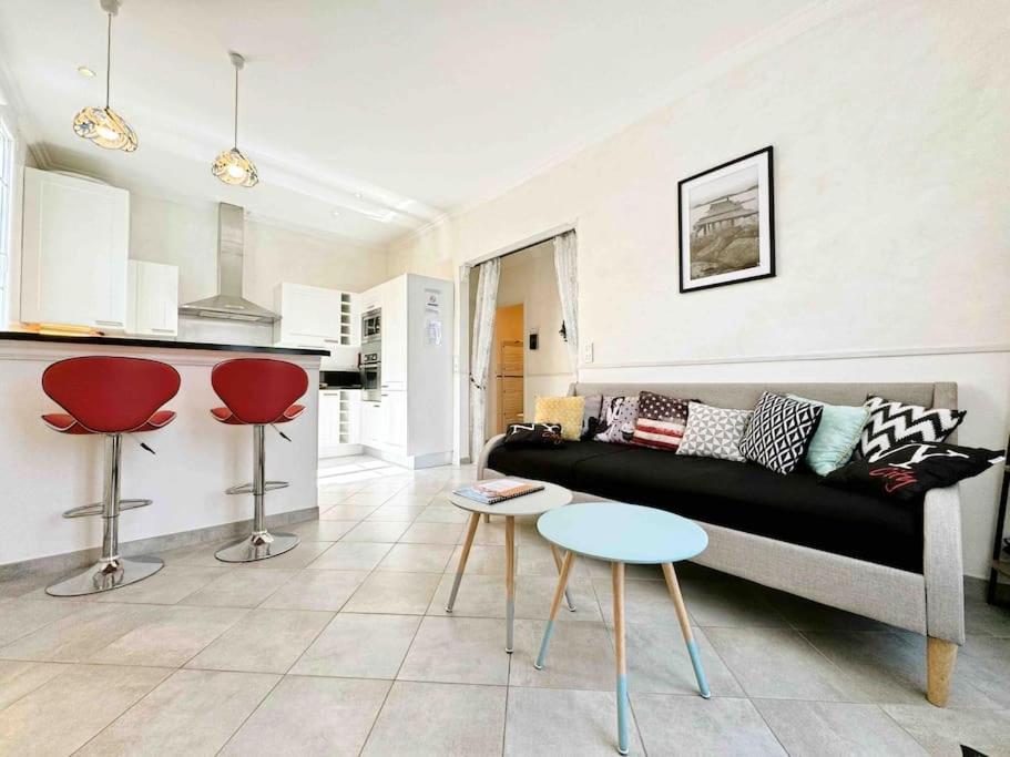 - un salon avec un canapé noir et des fauteuils rouges dans l'établissement Le Biggi : Apt 3 Prs, jardin, 5 min plages, à Vallauris